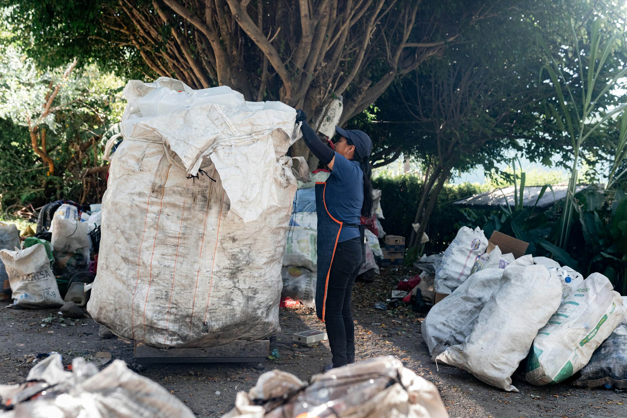 Hispanic Woman Managing Recycled Plastic at Recycling Site